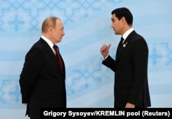 Russian President Vladimir Putin (left) speaks with Turkmen President Serdar Berdymukhammedov at a Caspian summit in Ashgabat in June.