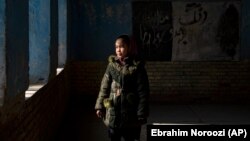 An Afghan schoolgirl stands in an empty classroom in Kabul after the Taliban barred teenage girls from attending secondary school.