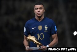 Cel mai bun marcator al Cupei Mondiale, atacantul francez Kylian Mbappe, pozează dezamăgit cu premiul Gheata de Aur, 18 decembrie 2022.