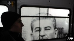 Волгоград. Мужчина в маршрутном такси с баннером, на котором изображен Иосиф Сталин. Архивное фото 