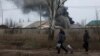 A couple walks past an industrial building that was hit by a missile strike on the front line in eastern Ukraine on December 25. 