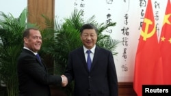 Dmitri Medvedev (stânga) și Xi Jinping