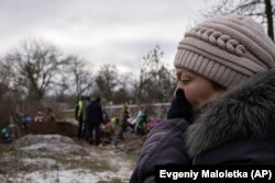 Tamila Pyhyda plânge în timpul exhumării soțului ei Serhii Pyhyda, care a fost ucis de forțele ruse în orașul recent recucerit Vysokopillya, Ucraina, luni, 5 decembrie 2022. (AP Photo/Evgeniy Maloletka)