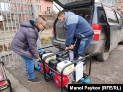 Мъже товарят част от генераторите, които ще бъдат изпратени в Украйна благодарение на кампанията.