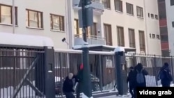 A video grab from Russian pro-government Telegram channels uploaded on December 20 shows masked men throwing sledgehammers over the fence of Finland's diplomatic mission in Moscow, but they do not reach the building itself.