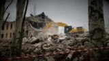 Mariupol, Ukraine -- A construction machine tearing down the remains of a building