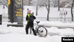 Žena gura bicikl kroz snijeg u središtu Stockholma, Švedska 21. studenog 2022. (Ilustrativna fotografija)