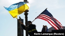 Рабочий устанавливает флаги США и Украины на Пенсильвания-авеню в Вашингтоне накануне очередного визита в США президента Украины Владимира Зеленского