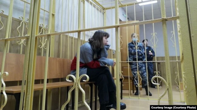 Olesya Krivtsova sits in the defendant's cage during a court hearing in January.