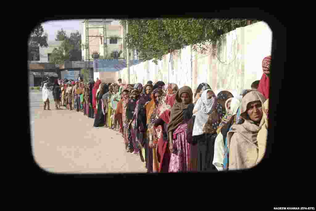 Women wait hours for subsidized bags of flour in Karachi on January 10. Dozens of countries and international institutions have pledged more than $9 billion to help Pakistan recover and rebuild following the floods, which environmentalists and scientists blamed on climate change.