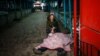 A woman kneels next to the body of her dead husband after Russian shelling of the Ukrainian city of Kherson on December 24.
