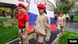 Участники движения «Юнармия» поднимают флаг перед уроками в школе в Москве (иллюстративное фото)