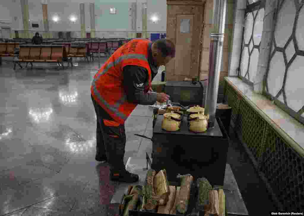Работник подготвува чај на шпорет на дрва на железничка станица во Киев на 25 ноември. Во услови на геополитички превирања предизвикани од руската инвазија на Украина во февруари, испораките на гас од Русија во Европа се намалени за околу 88 отсто, што ги зголемува веќе спиралните трошоци за горивата за греење. Како резултат на тоа, многу луѓе се принудени да се свртат кон поевтини, повалкани, алтернативни горива за греење, како што се дрво и јаглен со низок квалитет.