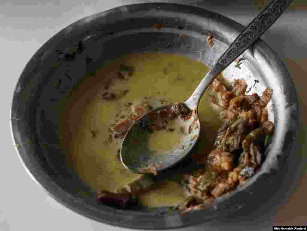 A plate with frozen food is seen in the apartment of Tetyana Reznychenko. Her apartment has no electricity, heating, or water and is on the fifth floor of a building heavily damaged by a Russian military strike in the Ukrainian village of Horenka.