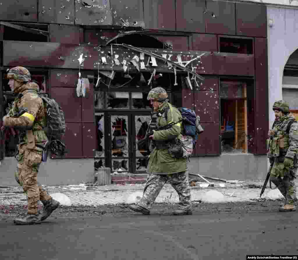 Troops file past a ruined cafe in Bakhmut. The continuous incoming shelling, Dubchak says is &ldquo;really crazy, really scary&rdquo; in the center of Bakhmut because &ldquo;Russia shells without any logic.&rdquo;&nbsp;