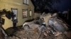 A man stands next to cars destroyed by a Russian missile strike in a residential area in Kharkiv on December 8.