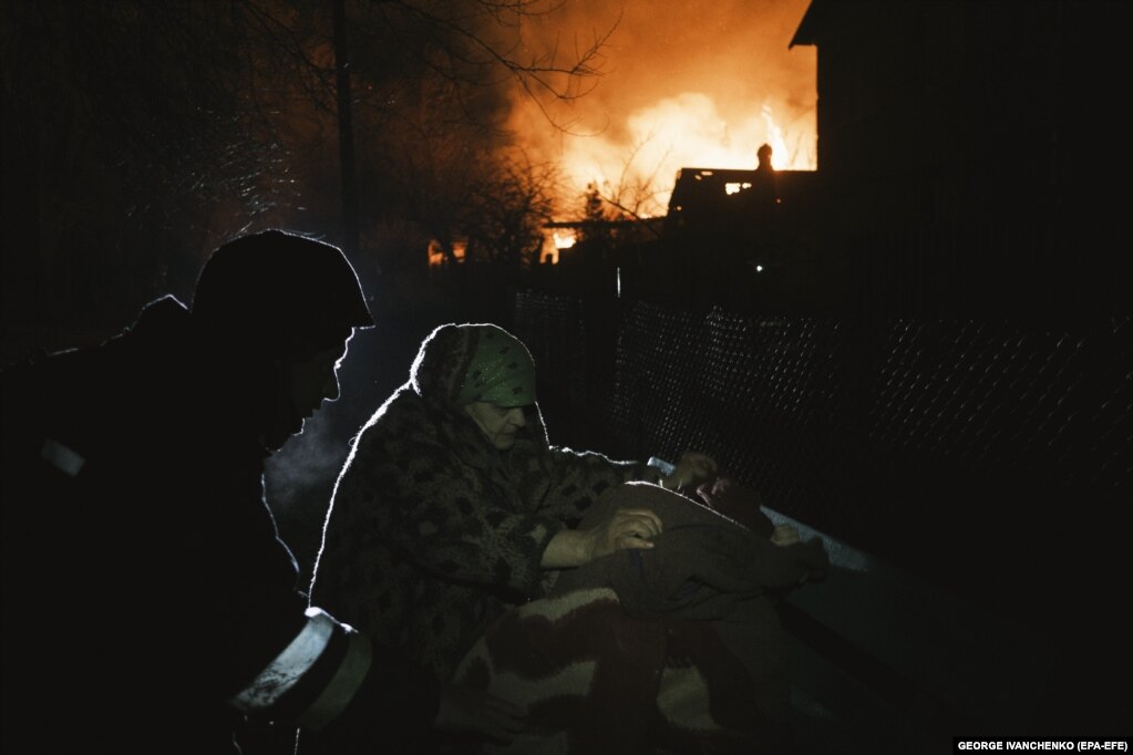 Një banore lokale shihet duke mbledhur gjësende afër një ndërtese të djegur nga bombardimet ruse në rajonin ukrainas Donjeck.