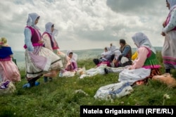 Dukhobors, dressed in their traditional garb, gather on a mountaintop on a spiritual holiday.