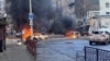 Mașini arzând pe o stradă din Herson după un bombardament rusesc, 24 decembrie 2022