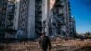 Un bărbat trece pe lângă un bloc de locuințe distrus din orașul Liman, regiunea Donețk, 4 ianuarie 2023.