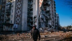 Un bărbat trece pe lângă un bloc de locuințe distrus din orașul Liman, regiunea Donețk, 4 ianuarie 2023.