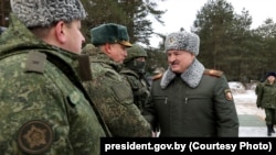 Александър Лукашенко във военна униформа инспектира учения. 