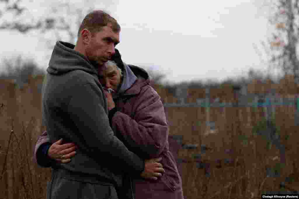 The thud of distant explosions can be heard as Mykola Melenets comforts his mother and Oleksandr&#39;s coffin is lowered into its final resting place -- nearly seven months after he was killed.