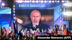 Predsjednik Rusije Vladimir Putin na ekranu na moskovskom Crvenom trgu u septembru 2022. dok se obraća na skupu obilježavanja pokušaja aneksije četiri djelimično okupirane regija Ukrajine nakon organizovanja lažiranih referenduma.