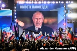 Putin is seen on a screen on Moscow's Red Square as he addresses a rally in September marking Russia's claim to have annexed four Ukrainian regions, which none of its forces fully control.