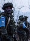 Protesters stand in front of Russian peacekeepers on the road outside Stepanakert, the de facto capital of Nagorno-Karabakh, on December 24, 2022. 
