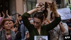 Një iraniane që jeton në Turqi, duke prerë flokët në mbështetje të protestave të grave në Iran. Fotografi nga arkivi. 
