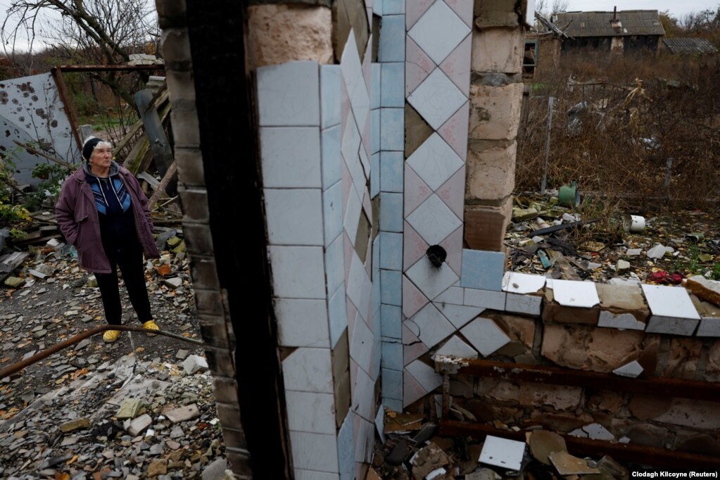 62-річна Ніна Меленець стоїть біля свого зруйнованого будинку в селі Кам’янка, що на околиці Ізюма Харківської області. Нещодавно вона повернулася додому, щоб організувати похорон свого загиблого старшого сина, 44-річного Олександра
