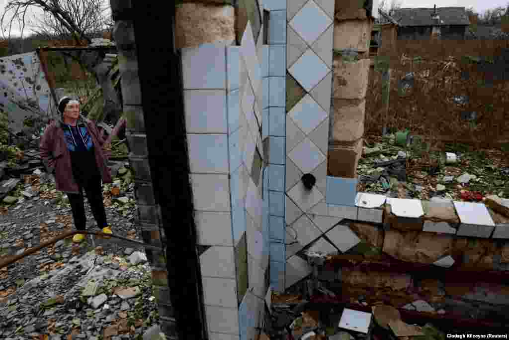 Nina Melenets, 62, stands outside her destroyed home in the village of Kamyanka, on the outskirts of Izyum, in the Kharkiv region. She recently returned home to organize the funeral of her eldest son, Oleksandr, 44, who was killed earlier in the conflict.