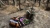 An empty coffin is placed next to a grave after the exhumation of bodies in the mass graves dug during the Russian occupation in the city of Izyum in eastern Ukraine.