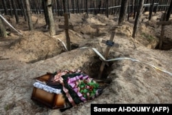Sicriu gol, în timpul unei intervenții de exhumare a cadavrelor într-un cimitir din Izium, estul Ucrainei, unde au fost descoperite peste 400 de morminte și o groapă comună.