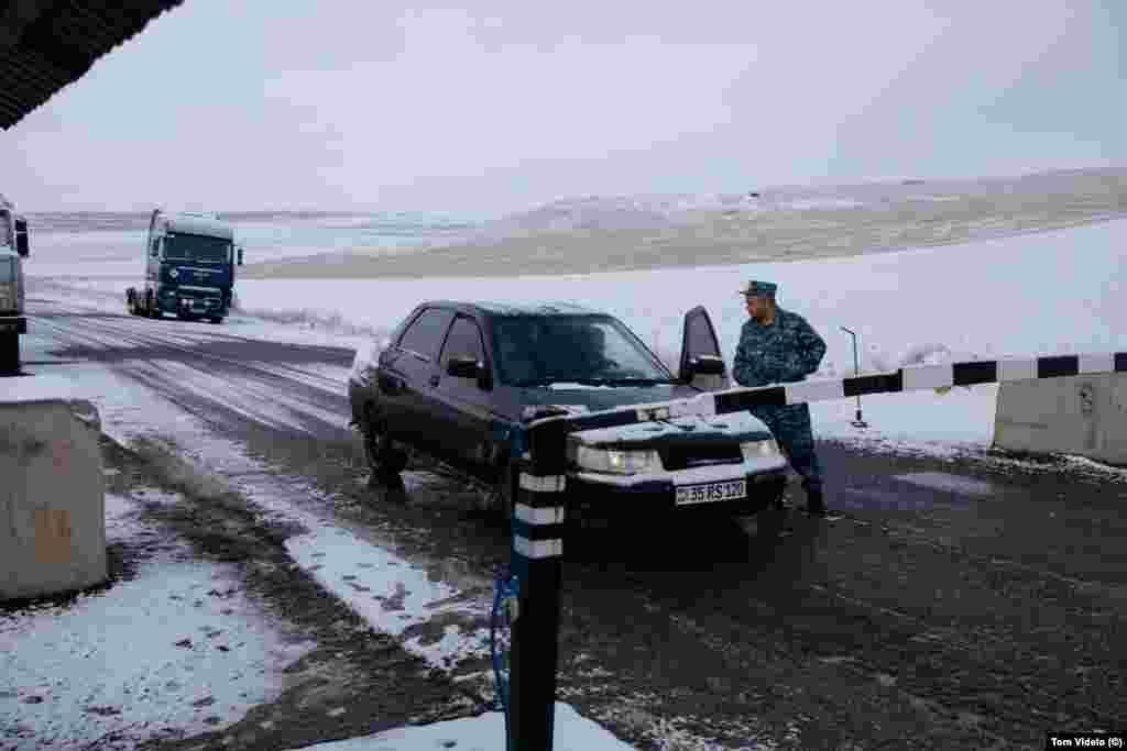 An ethnic Armenian policeman speaks to a driver at the Tegh checkpoint. Armenian authorities began preventing anyone except local villagers from proceeding past this post shortly after the blockade began on December 12. &nbsp;