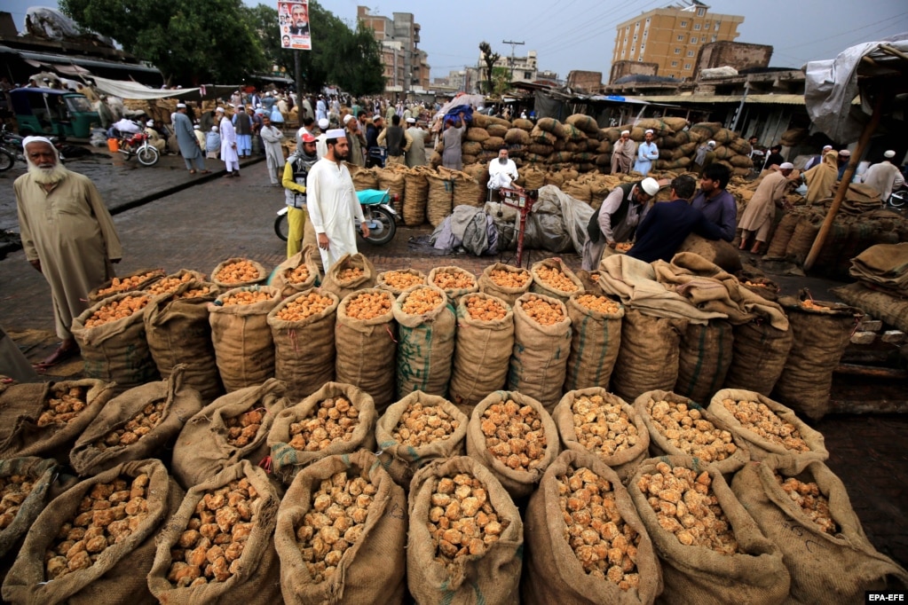 Disa pakistanezë shihen duke shitur sheqer në një treg në Peshavar.