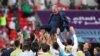 Iranian players celebrate with coach Carlos Queiroz after the match against Wales on November 25.