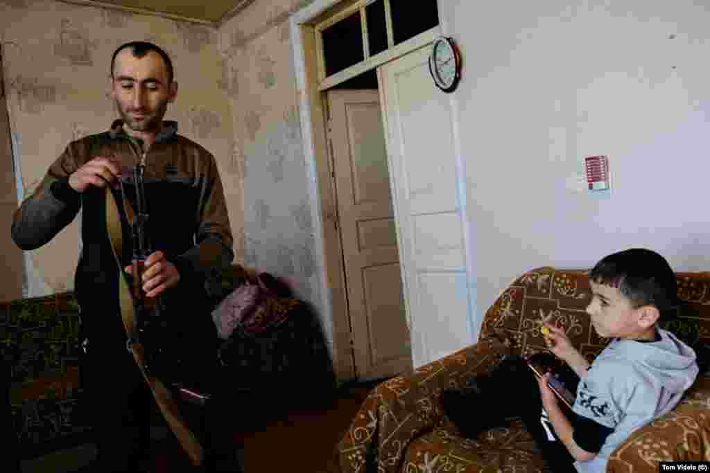 Ruben Balian and his son Garnik in their house in Kornidzor, a village near the blockaded road connecting Armenia with Nagorno-Karabakh. Balian is a member of Armenia&rsquo;s territorial defense organization and keeps an AK-47 rifle at home. Many fear another breakout of all-out war could be possible amid the ongoing tensions over Nagorno-Karabakh.