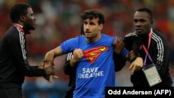 Mario Ferri is detained by officials after encroaching onto the field of play during Portugal's World Cup game against Uruguay on November 29 