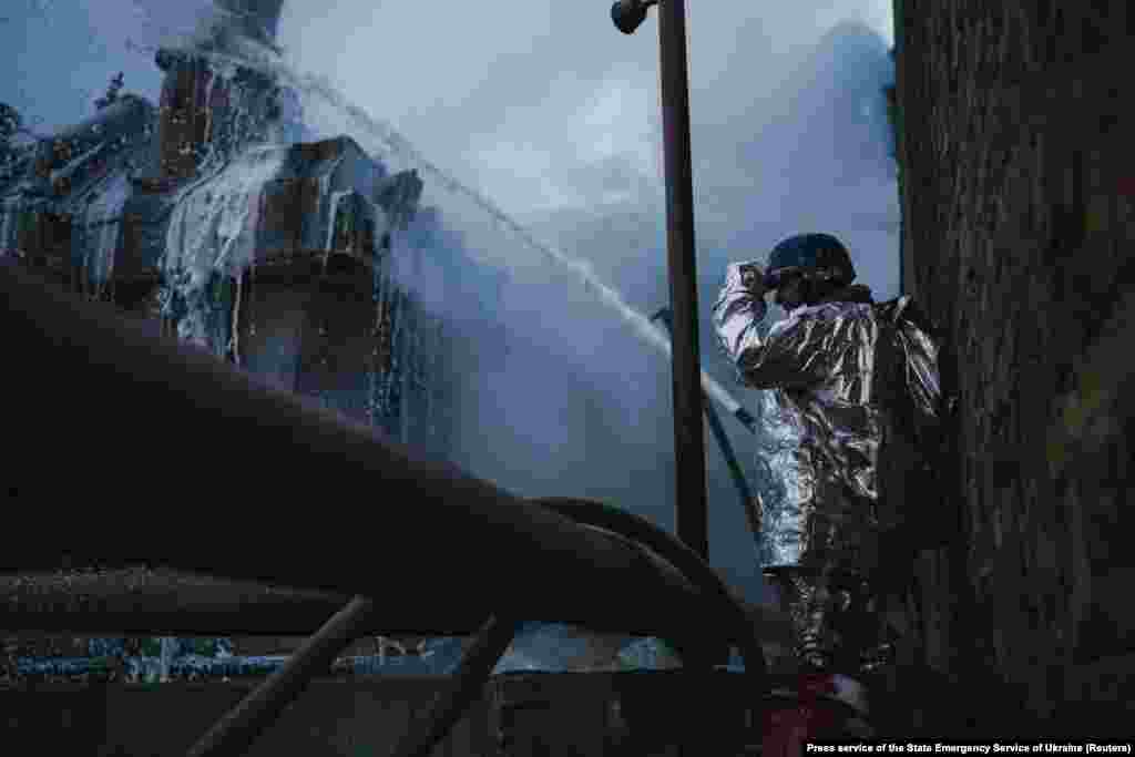 Рятувальник гасить пожежу на об&rsquo;єкті критичної енергетичної інфраструктури, який постраждав під час атак російських безпілотників на Київ,19 грудня 2022 року