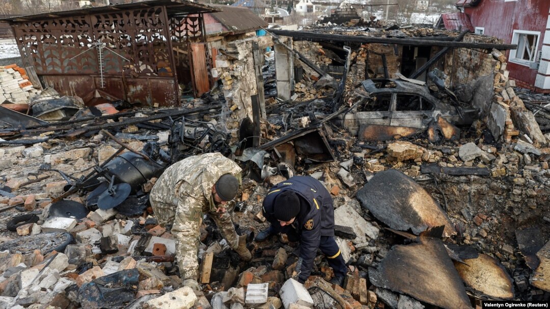 Investigators work at the site of a residential a building damaged during a Russian drone strike in the village of Stari Bezradychi in the Kyiv region on December 19.