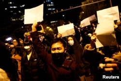 Manifestanții au ținut foi albe în semn de protest față de restricții și față de cenzura autoritățile ochineze, în timpul protestului organizat în Beijing, China, pe 27 noiembrie 2022.