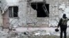 A Ukrainian war crime prosecutor inspects a residential building damaged by a Russian military strike in Kherson, Ukraine, on December 1, 2022.