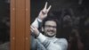  Ilya Yashin gestures from inside a defendant's cage in a Moscow courtroom in December 2022. 