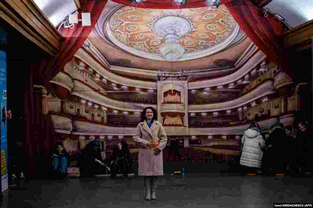 Дівчина співає, поки люди ховаються у станції метро під час повітряної тривоги в центрі Києва, 16 грудня 2022 року
