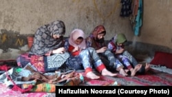 تصویر آرشیف: یک مادر با دخترانش خامکدوزی می کند