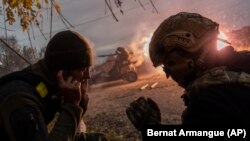 Ukrainian soldiers fire toward Russian positions on the front line near Kherson.