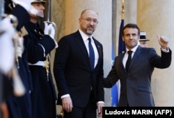 Президент Франції Емманюель Макрон (п) вітає в Єлисейському палаці премʼєр-міністра України Дениса Шмигаля, який прибув для участі в донорській конференції, Париж, 13 грудня 2022 року