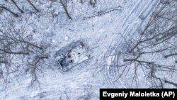 Знищений російський танк, засипаний снігом, стоїть у лісі в Харківській області, Україна, 14 січня 2023 року